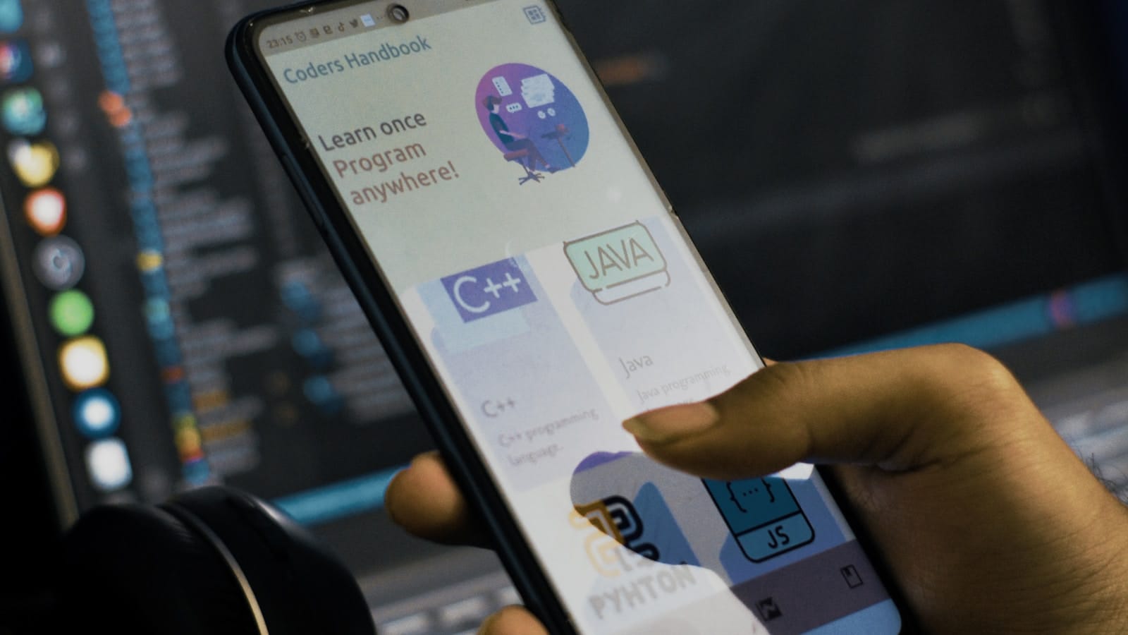Mano sosteniendo un teléfono Android frente a una pantalla con código